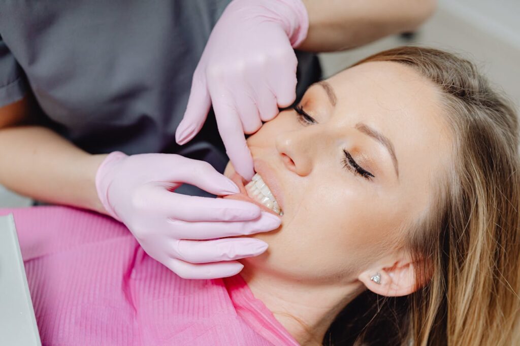 pexels photo 6627537 A dentist wearing gloves examines a patient's teeth in a close-up view during a dental check-up.